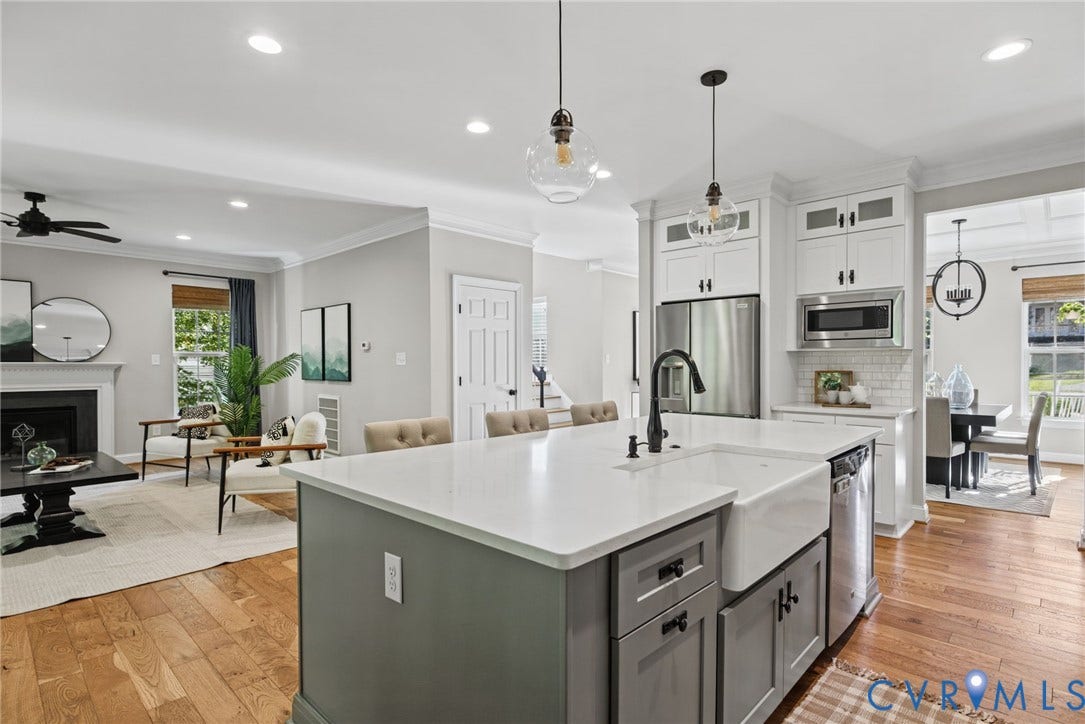 1425 Montcroft Way, Midlothian, VA 23112 Kitchen featuring an expansive island with a farmhouse-style sink, quartz countertops, stainless steel appliances, white cabinetry, and wood-finish flooring