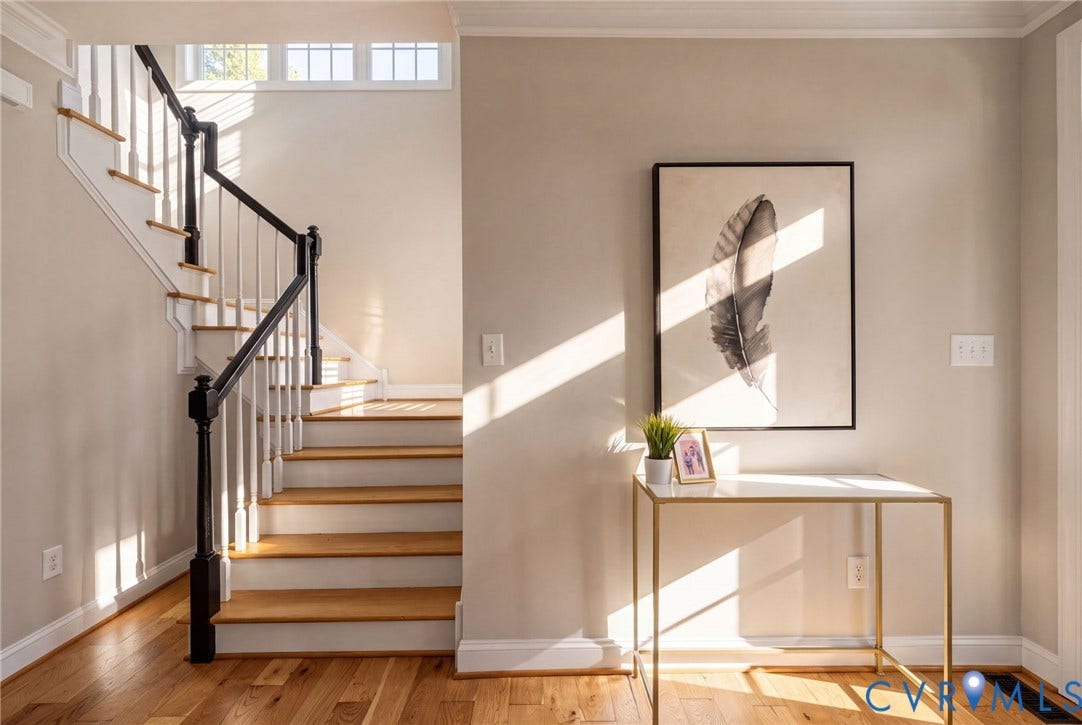 1425 Montcroft Way, Midlothian, VA 23112 Staircase featuring wood-finish treads, white risers, a black-finished handrail, and white balusters, complemented by wood-finish flooring