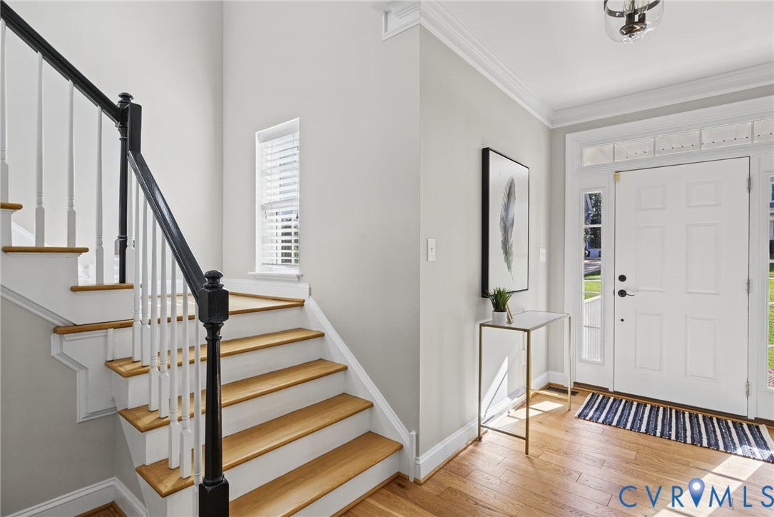 1425 Montcroft Way, Midlothian, VA 23112 Foyer featuring wood-finish flooring, a six-panel entry door with transom and side light windows, a staircase with a black handrail and white balusters, and crown molding