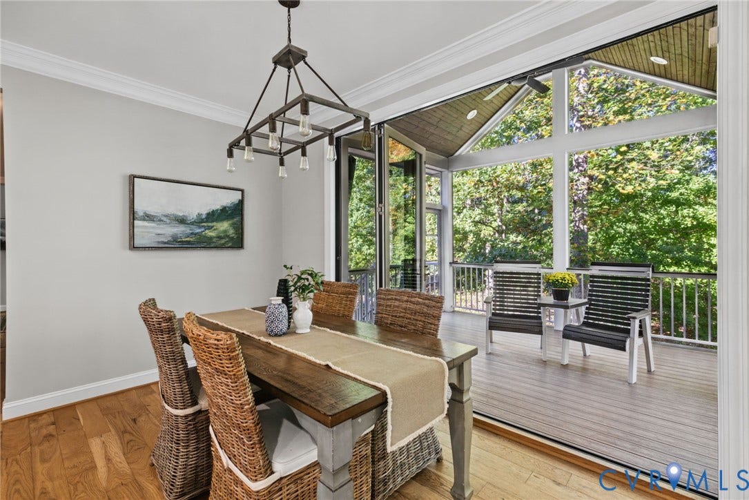 1425 Montcroft Way, Midlothian, VA 23112 Dining area featuring wood-finish flooring, crown molding, a multi-light industrial chandelier, and floor-to-ceiling bi-fold glass doors opening to a covered deck with wood-finish decking and a peaked tongue-and-groove ceiling