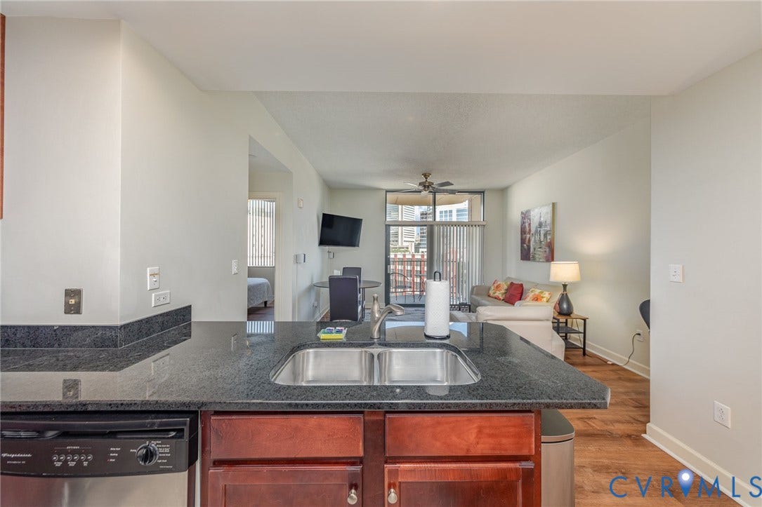 1101 Haxall Point, #709, Richmond, VA 23219 Kitchen features a double basin stainless steel sink, dark granite countertop, and integrated dishwasher