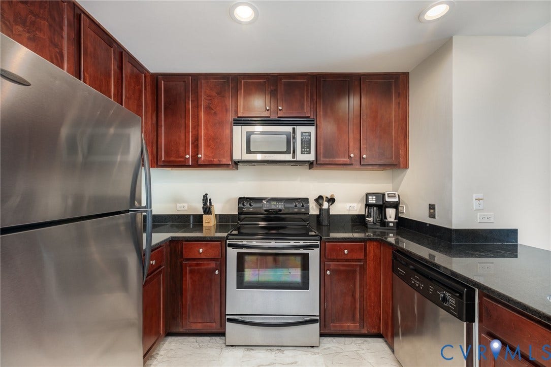 1101 Haxall Point, #709, Richmond, VA 23219 Kitchen featuring stainless steel appliances, dark wood-finish cabinetry, black countertops, and recessed lighting