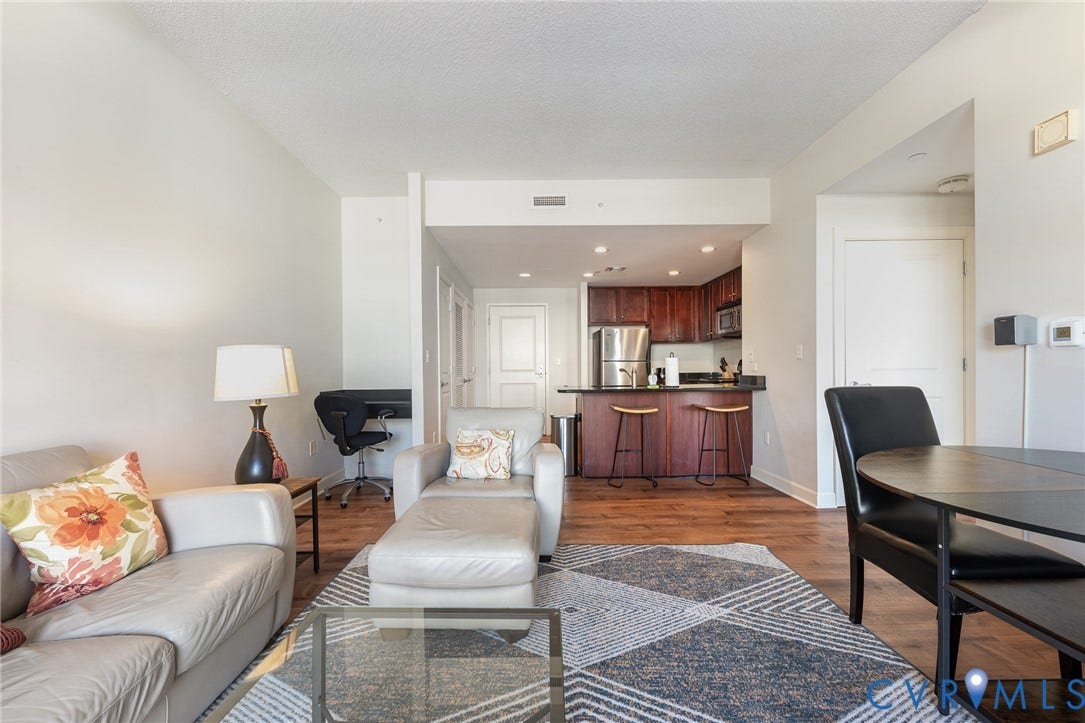 1101 Haxall Point, #709, Richmond, VA 23219 Open-concept living space featuring wood-finish flooring, recessed lighting, and a kitchen with dark wood cabinetry and stainless steel appliances