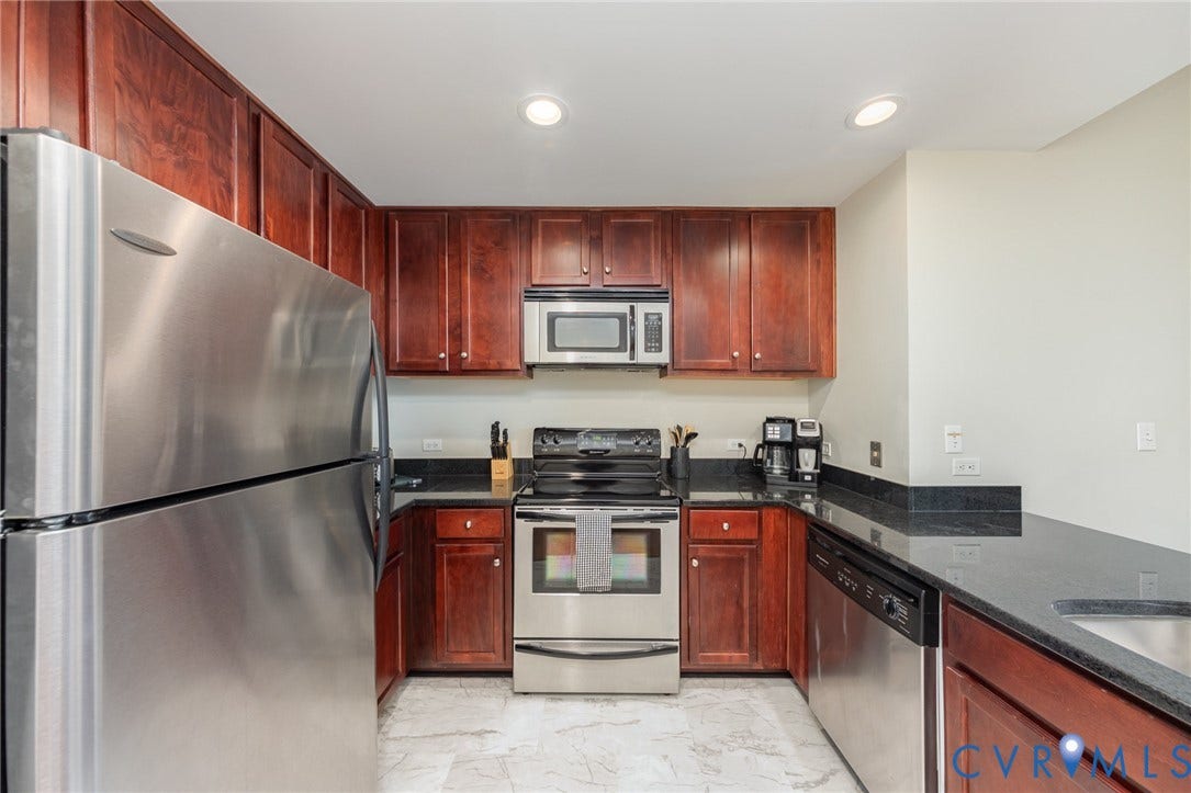 1101 Haxall Point, #709, Richmond, VA 23219 Kitchen featuring stainless steel appliances, dark wood-finish cabinetry, and dark countertops