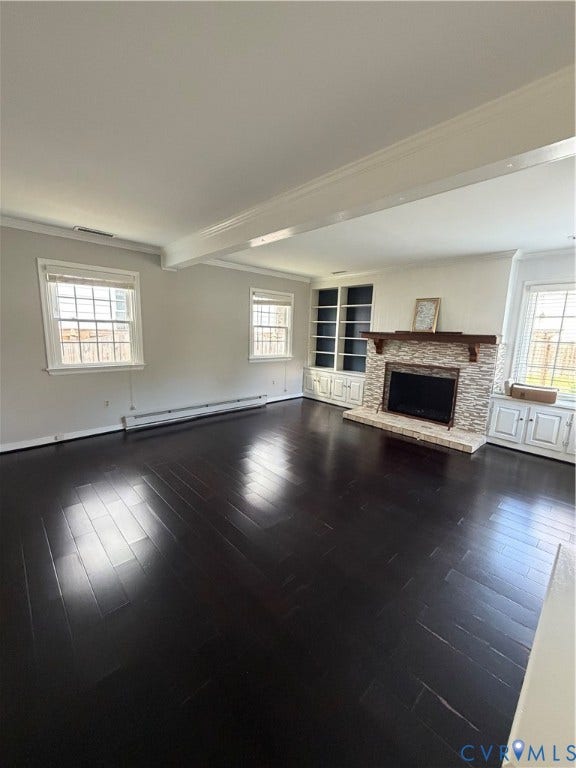 4612 Cutshaw Avenue, Richmond, VA 23230 Living area featuring wood-finish flooring, a fireplace with a stone-finish surround and wood mantel, and floor-to-ceiling built-in cabinetry