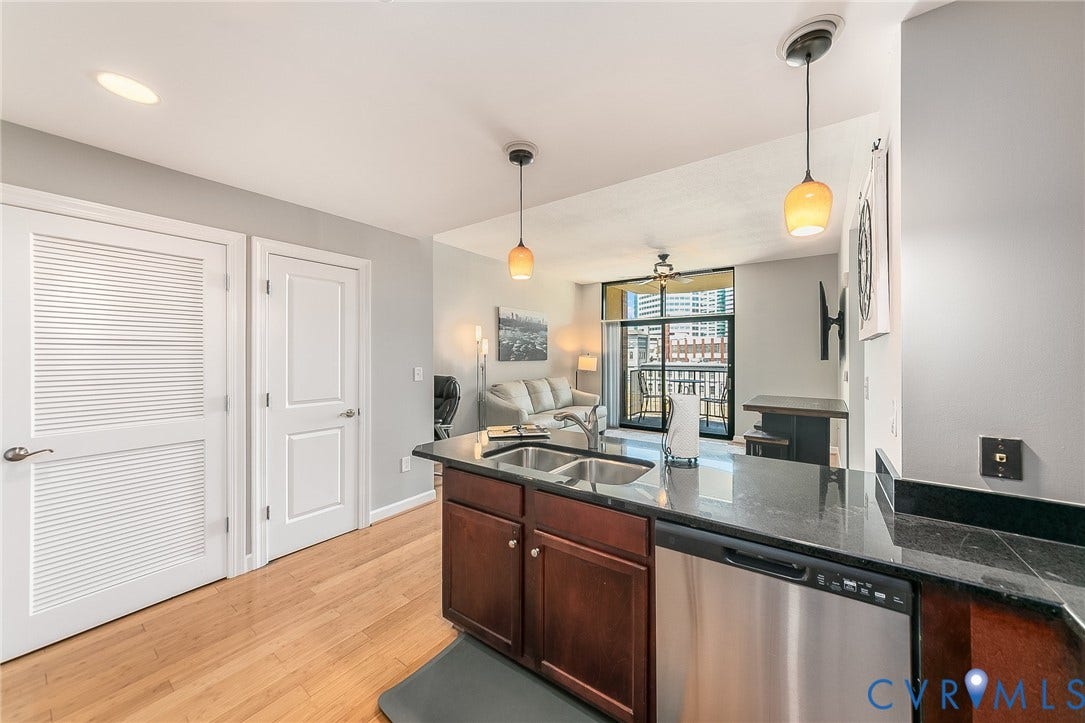 1101 Haxall Point, #511, Richmond, VA 23219 Kitchen featuring wood-finish flooring, dark stone countertops, and stainless steel appliances