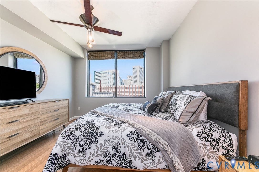 1101 Haxall Point, #511, Richmond, VA 23219 Room featuring wood-finish flooring, a ceiling fan with integrated lighting, and a large window with roller shades