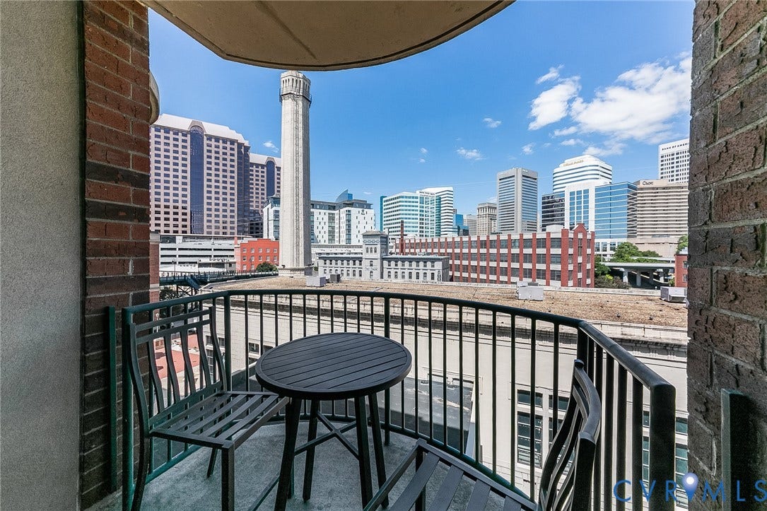 1101 Haxall Point, #511, Richmond, VA 23219 Private balcony with metal railing, brick exterior, and urban skyline