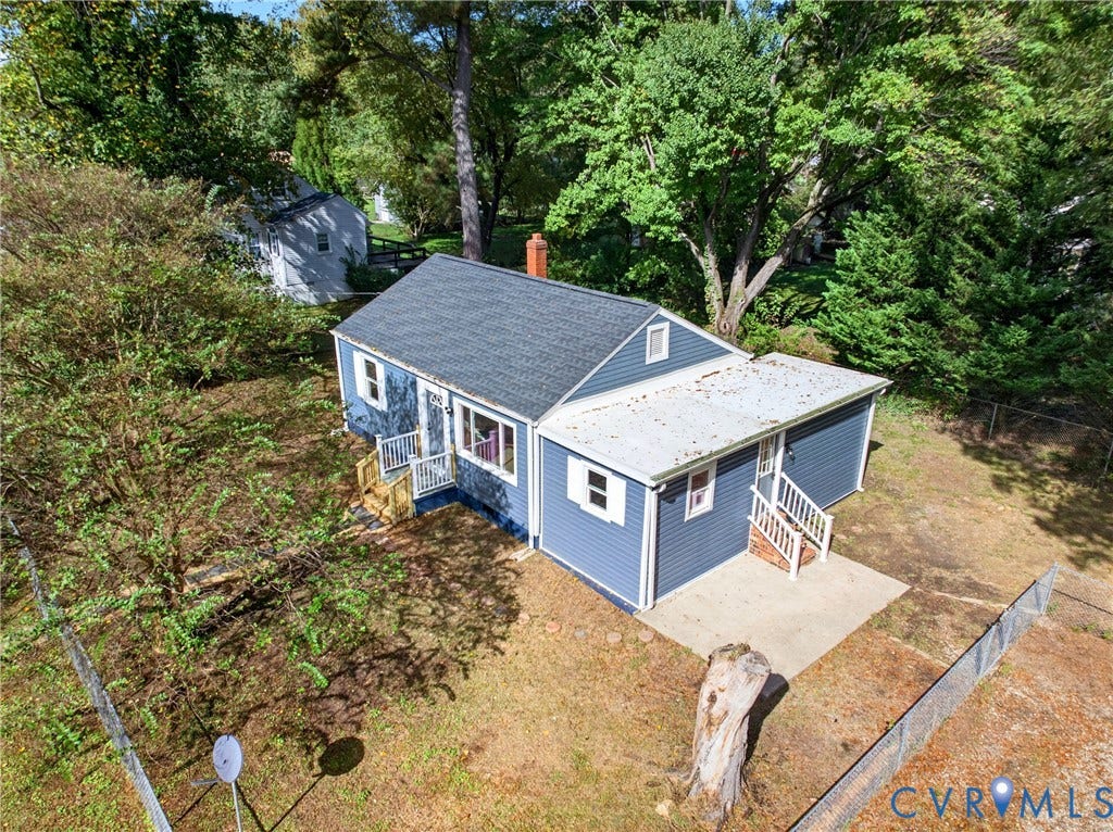 Blue siding exterior with a dark shingle roof and a concrete patio