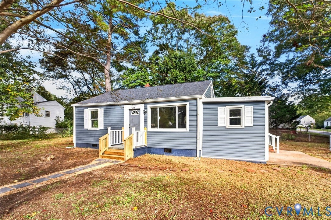 Blue siding exterior with white window shutters, a front entry door, and a wooden porch