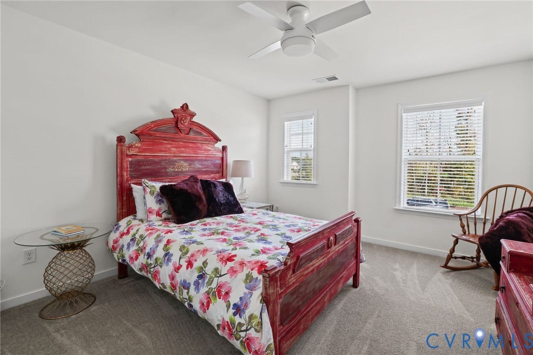 9337 Citrine Run, Henrico, VA 23238 Neutral-toned carpeting, white walls, dual windows with blinds, and a white ceiling fan with integrated lighting