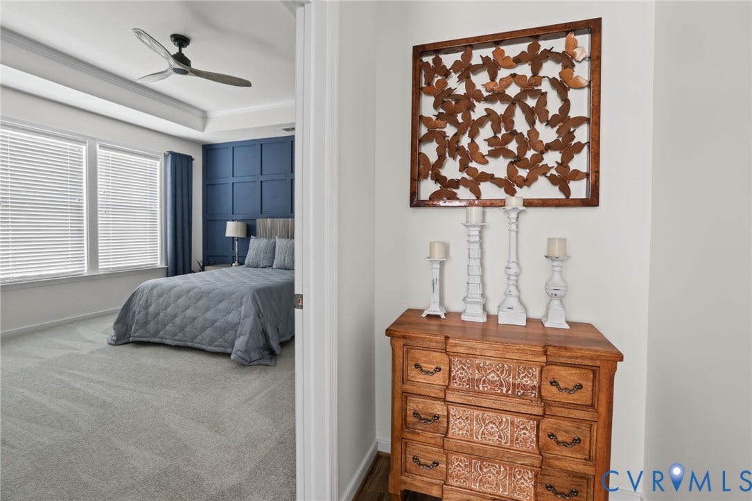 9337 Citrine Run, Henrico, VA 23238 Bedroom featuring a tray ceiling, ceiling fan, and blue paneled accent wall