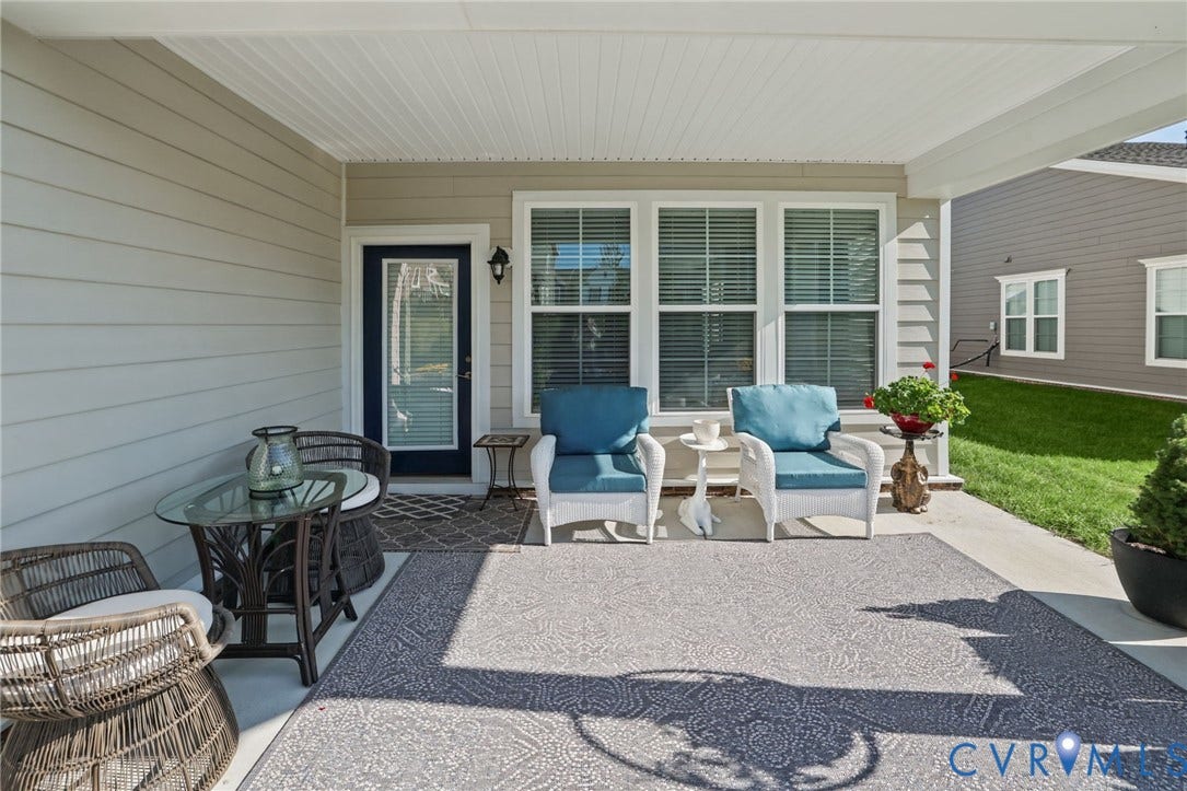 9337 Citrine Run, Henrico, VA 23238 Covered concrete patio featuring horizontal lap siding, multi-pane windows, and exterior wall-mounted lighting