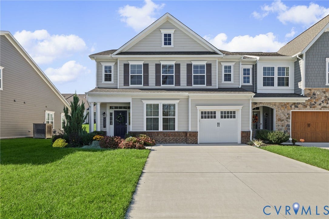 9337 Citrine Run, Henrico, VA 23238 Two-story residence featuring a lap siding exterior, stone veneer accents, multi-pane windows with decorative shutters, a covered front entryway, and a built-in garage