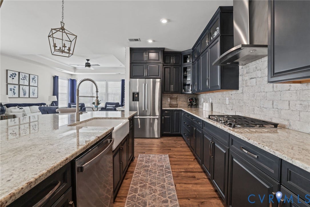 9337 Citrine Run, Henrico, VA 23238 Kitchen featuring floor-to-ceiling dark cabinetry, stone countertops, farmhouse-style apron sink, brick-style backsplash, and stainless steel appliances