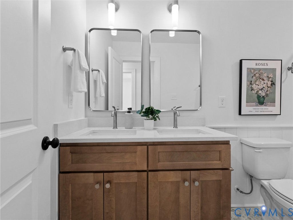 702 Westham Parkway, Westham, Henrico, VA 23229 Dual vanity with wood-finish cabinetry, integrated sinks, chrome faucets, and rectangular mirrors