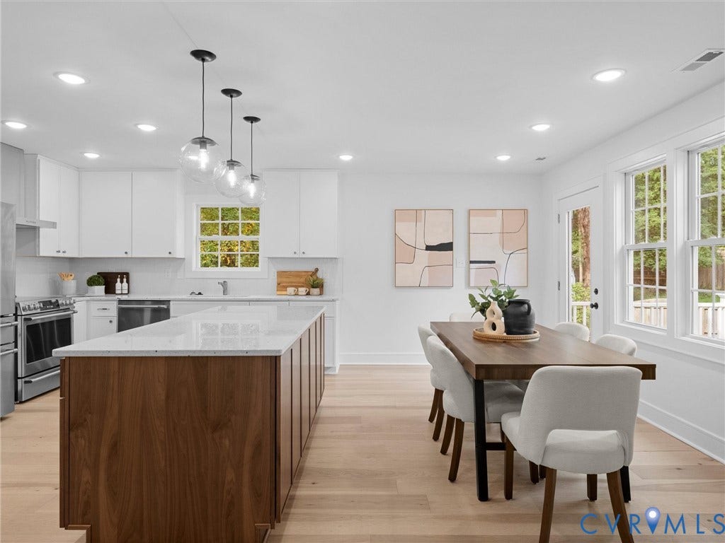 702 Westham Parkway, Westham, Henrico, VA 23229 Modern kitchen with a substantial wood-finish island, white cabinetry, integrated stainless steel appliances, and wood-finish flooring