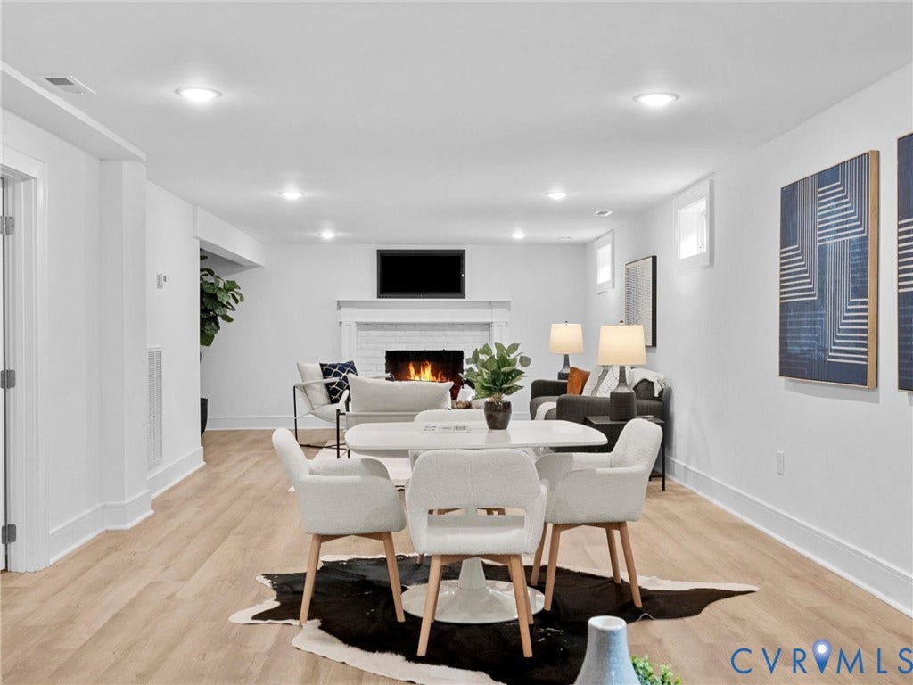 702 Westham Parkway, Westham, Henrico, VA 23229 Recessed lighting illuminates the open-concept space featuring wood-finish flooring, a white brick fireplace, and a built-in entertainment area