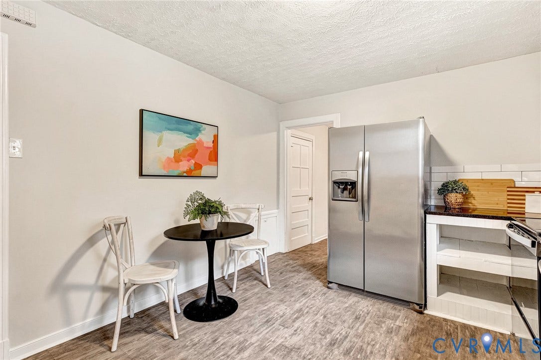 2817 Groveland Avenue, Green Park, Richmond, VA 23222 Wood-finish flooring, white subway tile backsplash, dark-toned countertop, and stainless steel refrigerator