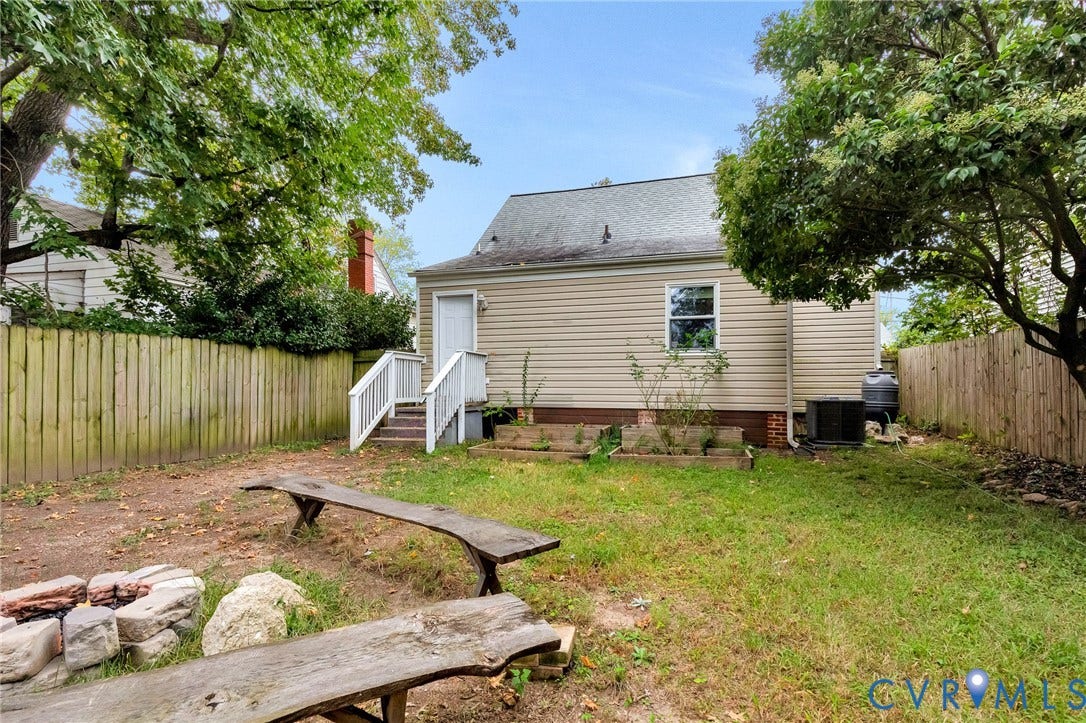 2817 Groveland Avenue, Green Park, Richmond, VA 23222 Backyard features a wood privacy fence, exterior stairs with white railings, and a window with white trim