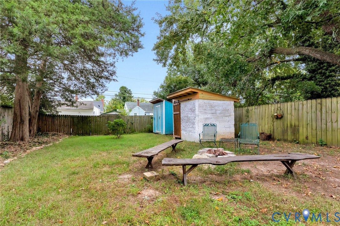 2817 Groveland Avenue, Green Park, Richmond, VA 23222 Expansive backyard featuring a fenced perimeter, a brick storage shed, and a dedicated fire pit area
