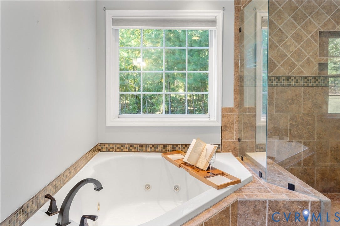 12380 Bienvenue Road, Bowles Acres, Rockville, VA 23146 Jetted soaking tub with dark finish faucet, tiled surround, glass-enclosed shower, and decorative mosaic tile accents