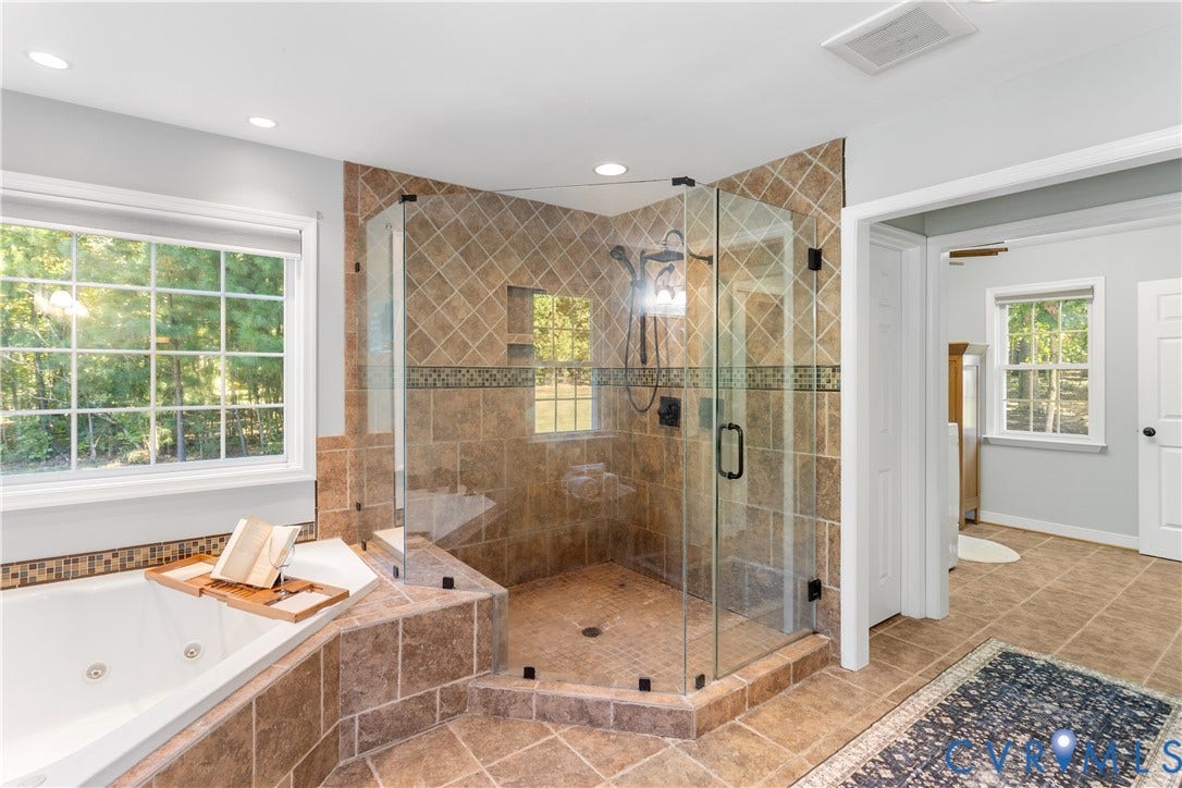 12380 Bienvenue Road, Bowles Acres, Rockville, VA 23146 Walk-in glass-enclosed shower with diagonal wall tile, integrated recessed shelving, multi-head shower fixture, corner jetted tub, and ceramic tile flooring. adjacent laundrey room, walkin closet