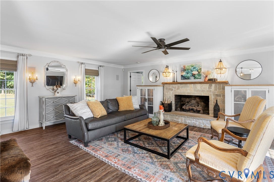 12380 Bienvenue Road, Bowles Acres, Rockville, VA 23146 Stone fireplace with a wooden mantel, wood-finish flooring, built-in cabinetry, crown molding, and ceiling fan