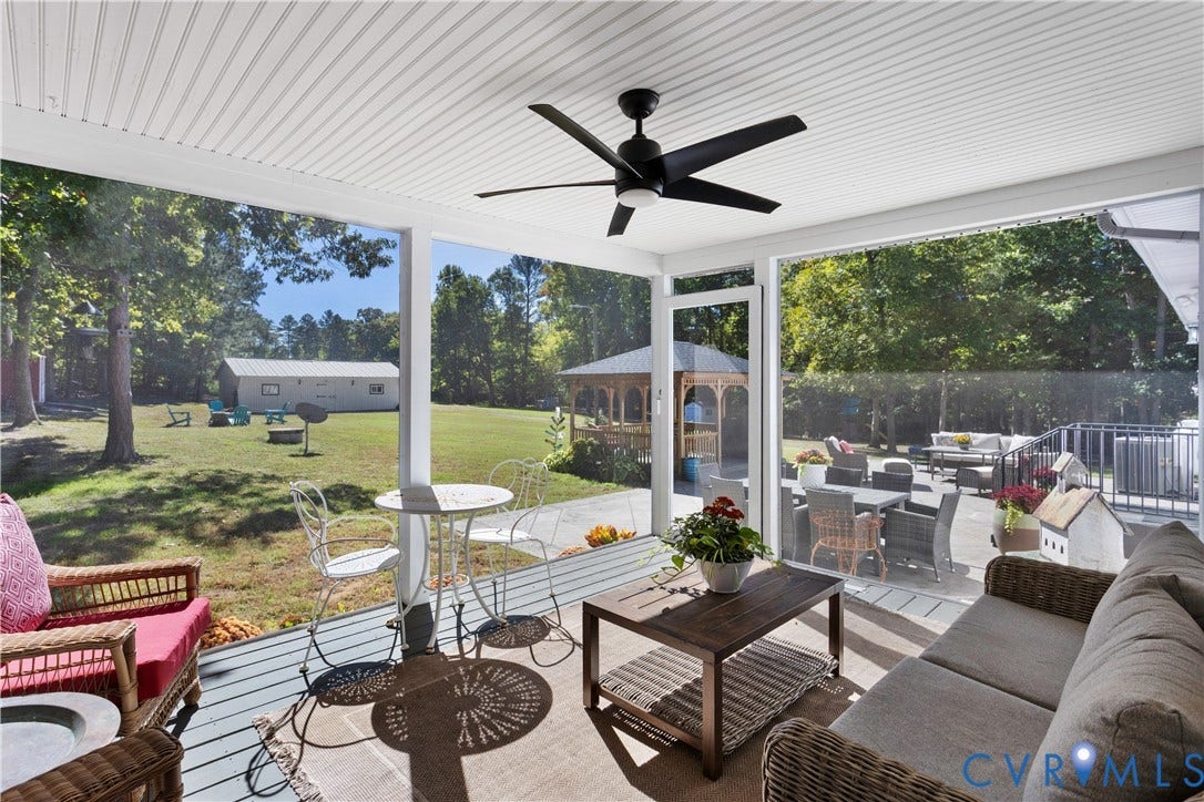 12380 Bienvenue Road, Bowles Acres, Rockville, VA 23146 Screened-in porch featuring a beadboard ceiling, a matte black ceiling fan, and painted decking over looking the 1000 sq ft concrete patio / Outdoor entertainment courtyard. Wow a great view of the barn & expansive yard!