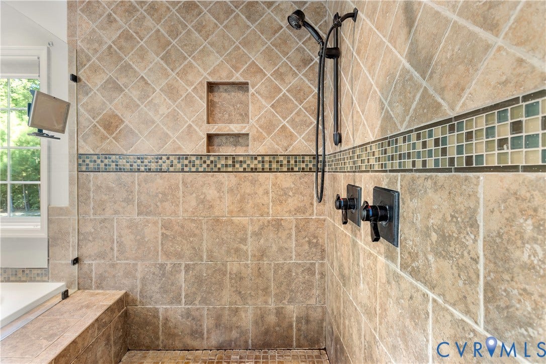 12380 Bienvenue Road, Bowles Acres, Rockville, VA 23146 Walk-in shower featuring large-format stone-finish wall tile, decorative glass mosaic tile inlay, built-in recessed storage niche