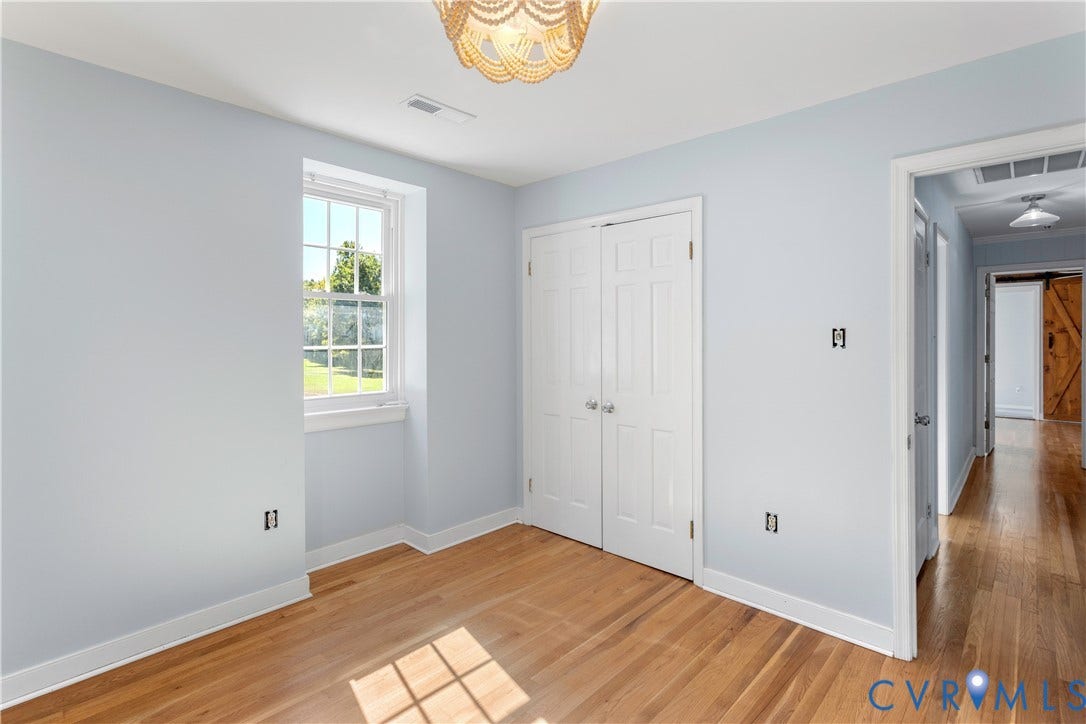 12380 Bienvenue Road, Bowles Acres, Rockville, VA 23146 Room with wood-finish flooring, double-door closet, multi-pane window, and decorative pendant light fixture