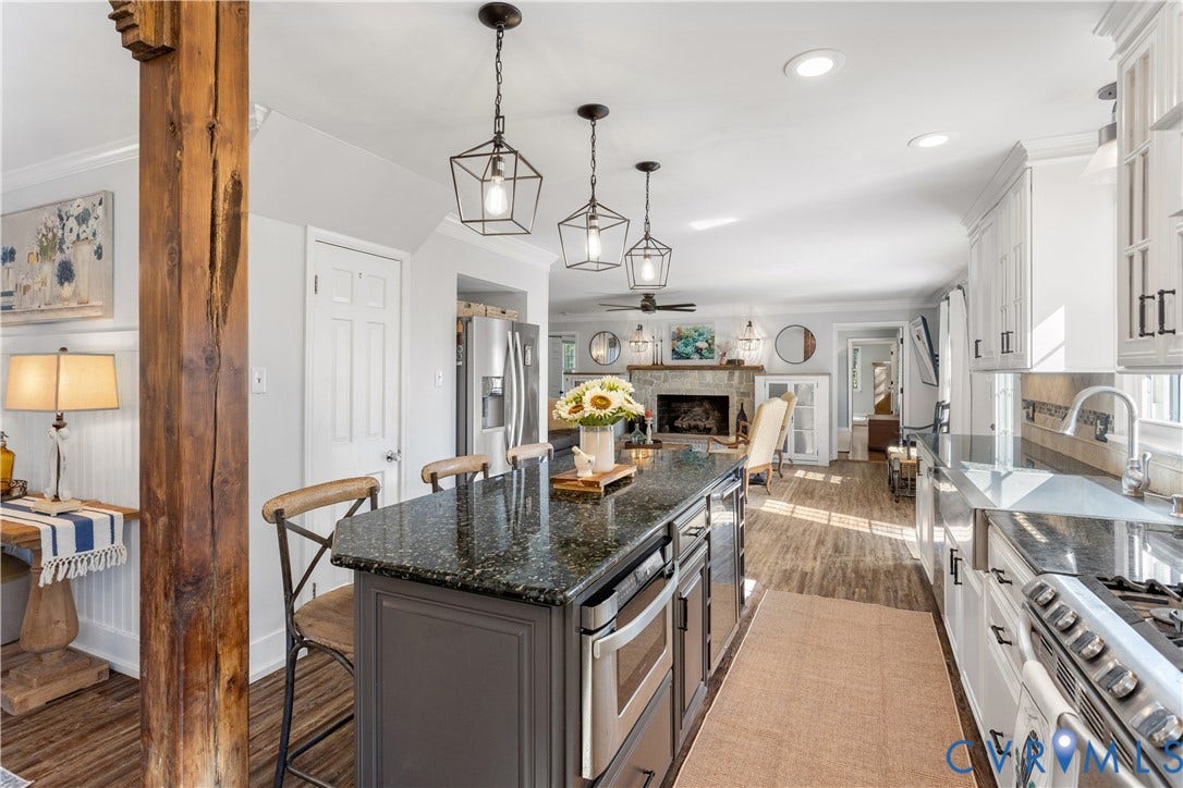 12380 Bienvenue Road, Bowles Acres, Rockville, VA 23146 Kitchen featuring a center island with granitw countertops, white cabinetry, rustic wood support column, stainless steel appliances, and geometric pendant lighting