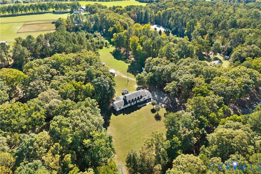 12380 Bienvenue Road, Bowles Acres, Rockville, VA 23146 Aerial perspective of a multi-story residence situated on a wooded lot featuring expansive grass clearings and a private driveway
