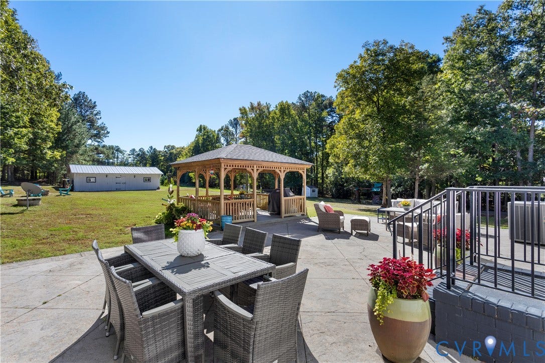 12380 Bienvenue Road, Bowles Acres, Rockville, VA 23146 Expansive backyard featuring a concrete patio, a wooden gazebo, mature trees, and a detached outbuilding