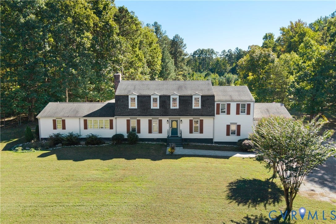 12380 Bienvenue Road, Bowles Acres, Rockville, VA 23146 Two-story colonial-style residence featuring a gambrel roof, white siding, decorative window shutters, and a brick chimney, situated on a expansive lot with mature trees