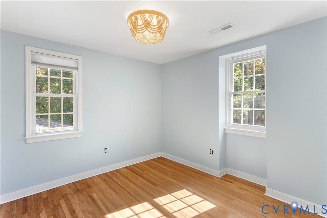 12380 Bienvenue Road, Bowles Acres, Rockville, VA 23146 Room featuring wood-finish flooring, two double-hung windows with muntins, and a circular beaded-style flush mount light fixture