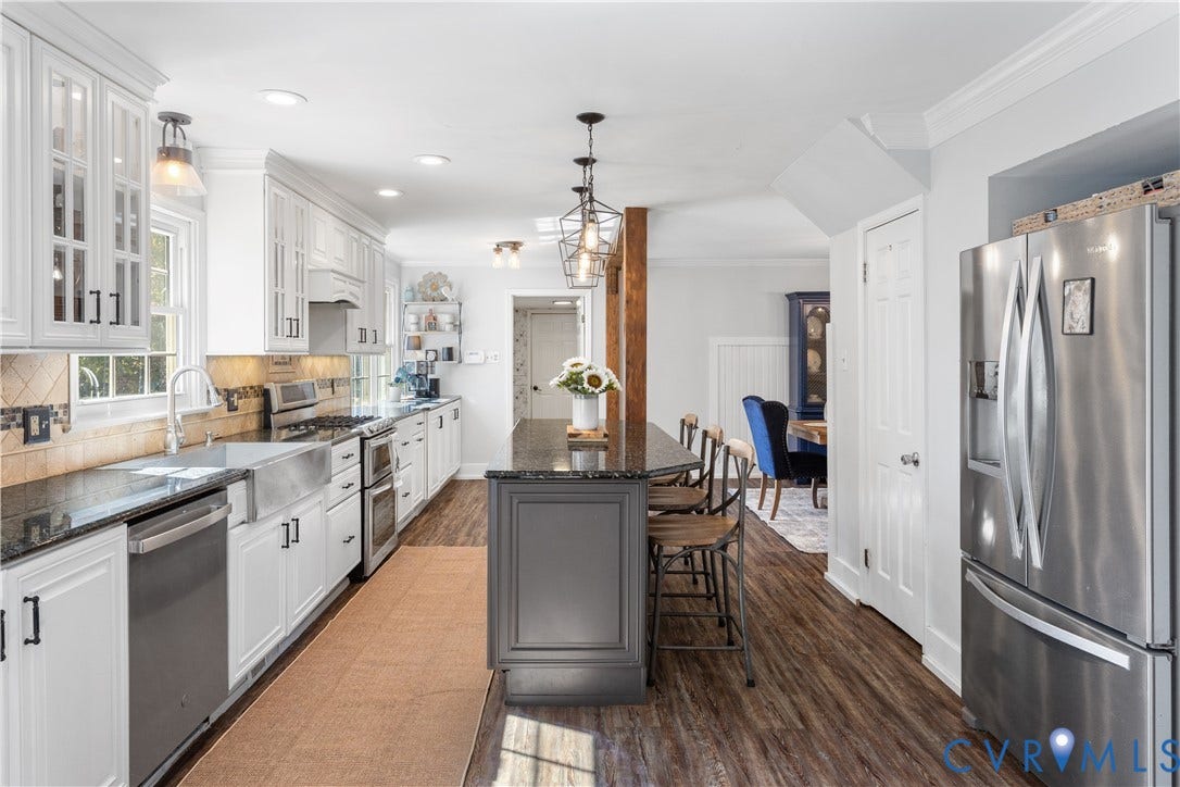 12380 Bienvenue Road, Bowles Acres, Rockville, VA 23146 Kitchen featuring white cabinetry with glass-panel accents, stone-finish countertops, stainless steel farmhouse sink, center island with charcoal-finish base, and wood-finish flooring