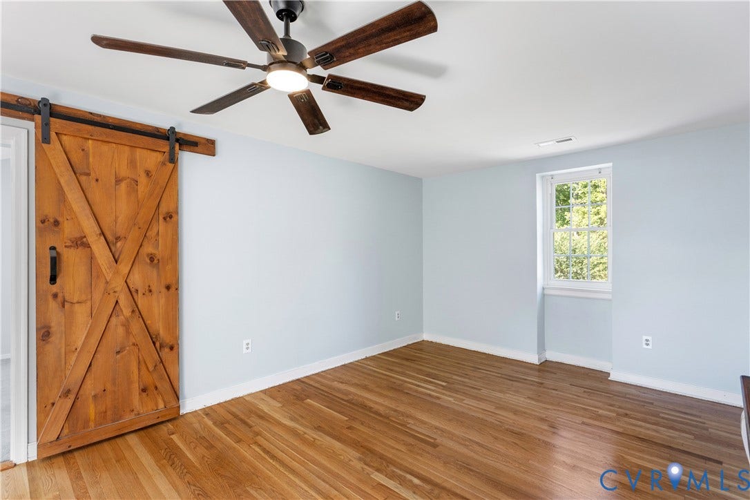 12380 Bienvenue Road, Bowles Acres, Rockville, VA 23146 Wood-finish flooring, wood-toned sliding barn door with black iron hardware,