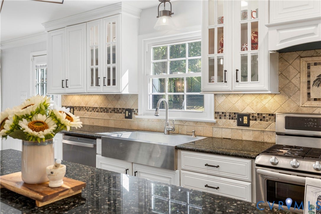 12380 Bienvenue Road, Bowles Acres, Rockville, VA 23146 Kitchen featuring white cabinetry with glass-front uppers, granite countertops, stainless steel farmhouse sink. Window over the sink with perfect views of the year yard and gazabow