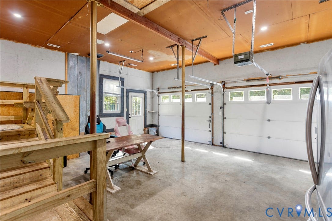 12380 Bienvenue Road, Bowles Acres, Rockville, VA 23146 Attached garage featuring concrete flooring, dual overhead door systems, recessed ceiling lighting, and a wood-framed staircase