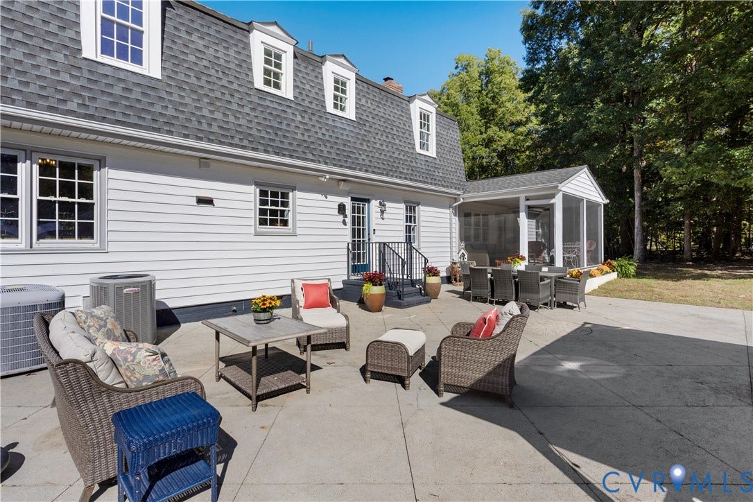 12380 Bienvenue Road, Bowles Acres, Rockville, VA 23146 Concrete patio featuring an attached screened-in porch, white horizontal siding, multiple dormer windows, and a shingled gambrel roof
