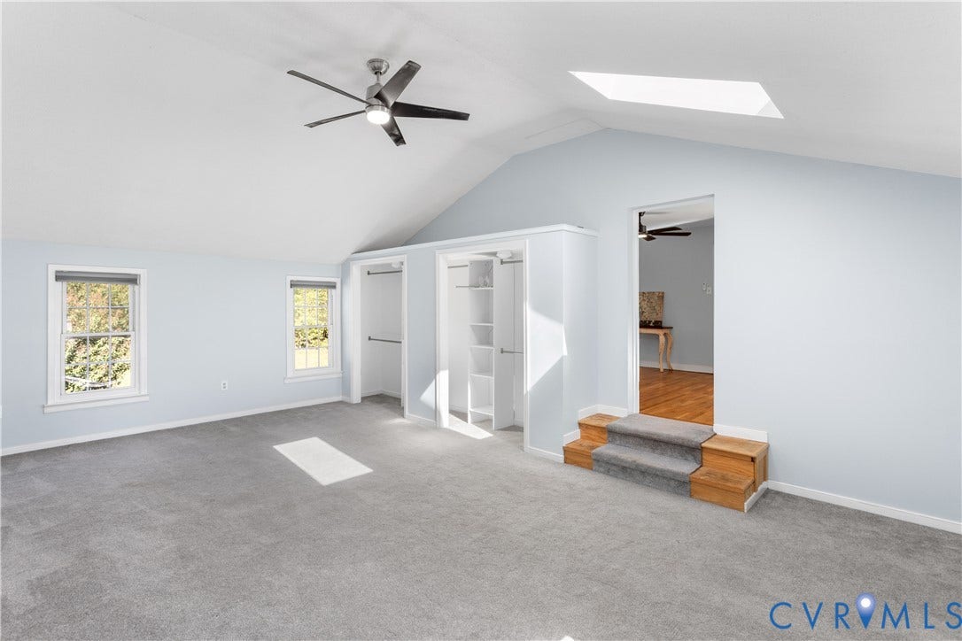 12380 Bienvenue Road, Bowles Acres, Rockville, VA 23146 Vaulted ceiling featuring a central skylight, built-in dual-closet system with shelving, integrated ceiling fan, and carpeted flooring with stepped entry