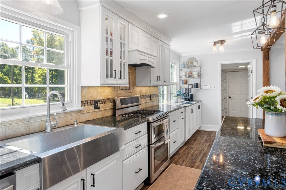 12380 Bienvenue Road, Bowles Acres, Rockville, VA 23146 Kitchen featuring white cabinetry, stainless steel farmhouse sink, stone countertops, wood-finish flooring, and industrial-style pendant lighting