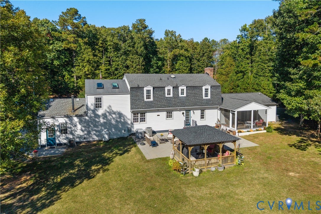 12380 Bienvenue Road, Bowles Acres, Rockville, VA 23146 Multi-level residence featuring a shingled roof with skylights, a concrete patio, a detached wooden gazebo, and a screened-in porch, all situated on a 7.9 acres