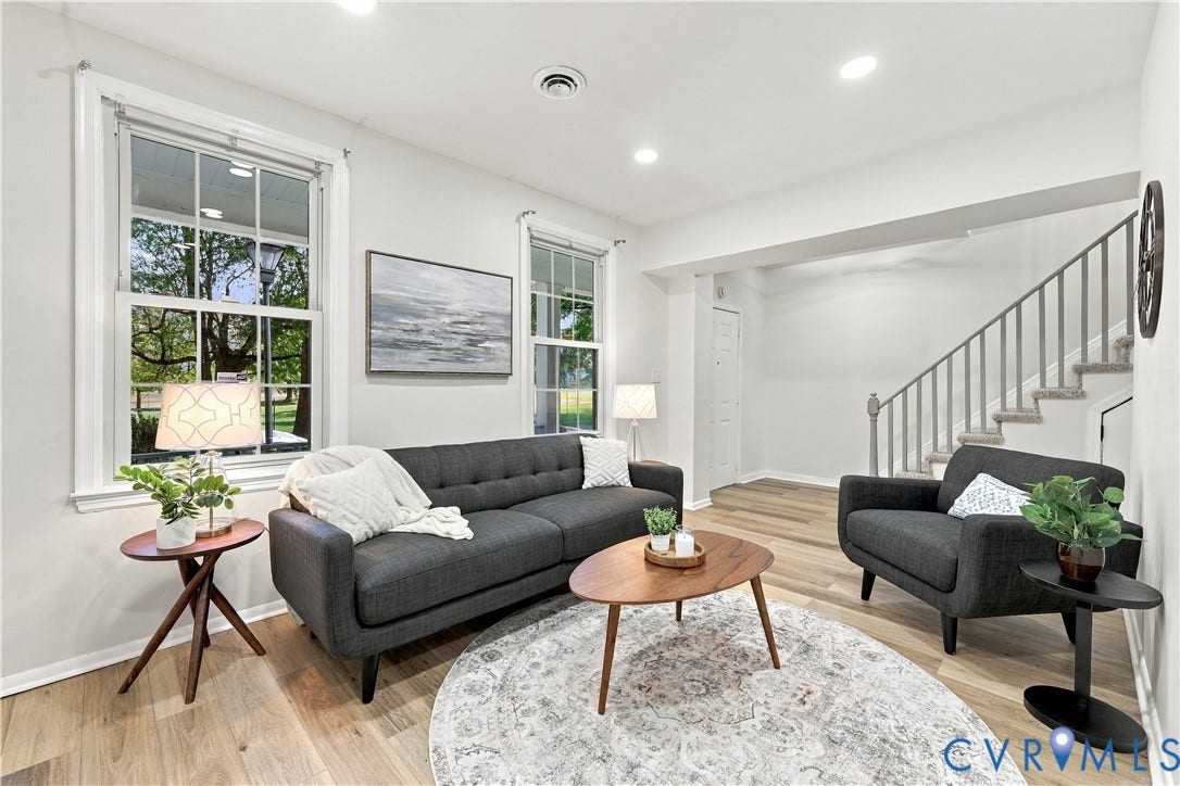 Wood-finish flooring, multi-pane windows, recessed lighting, and a staircase with a wooden handrail and balusters