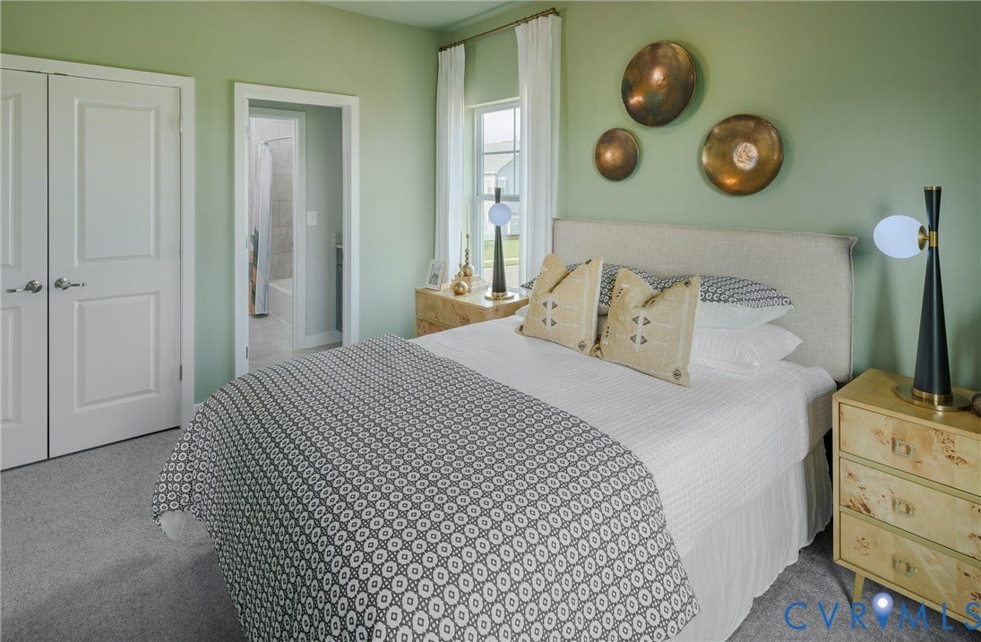 Neutral wall color, soft carpet flooring, double panel doors, and window with natural light