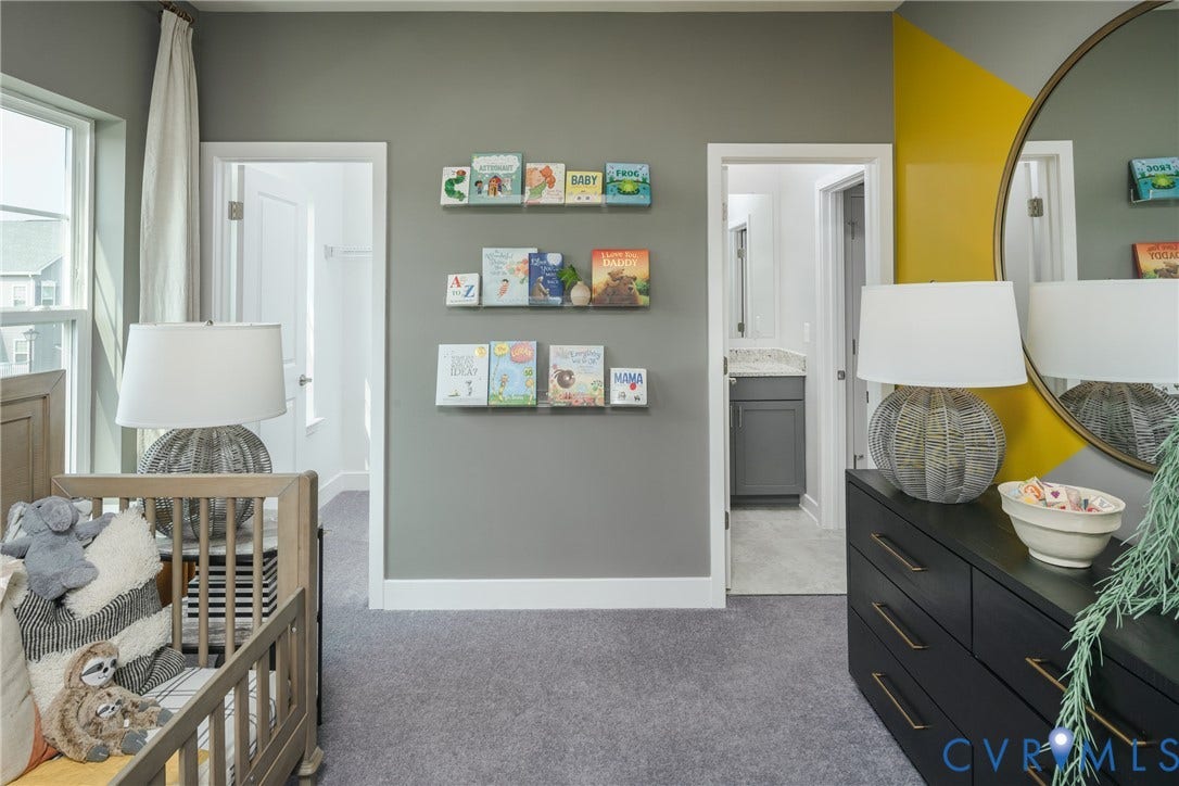 Wall-to-wall carpeting with light gray paint, white trim, and a patterned accent wall