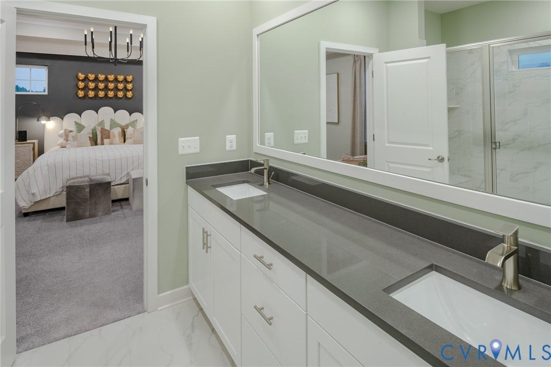 Dual vanity with an integrated rectangular sink, gray stone-finish countertop, and white cabinetry