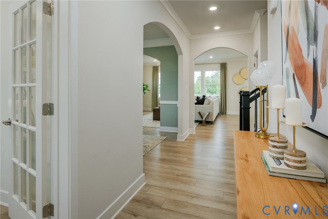 Archway entryways, wood-finish flooring, recessed lighting, French doors, and an open-concept layout