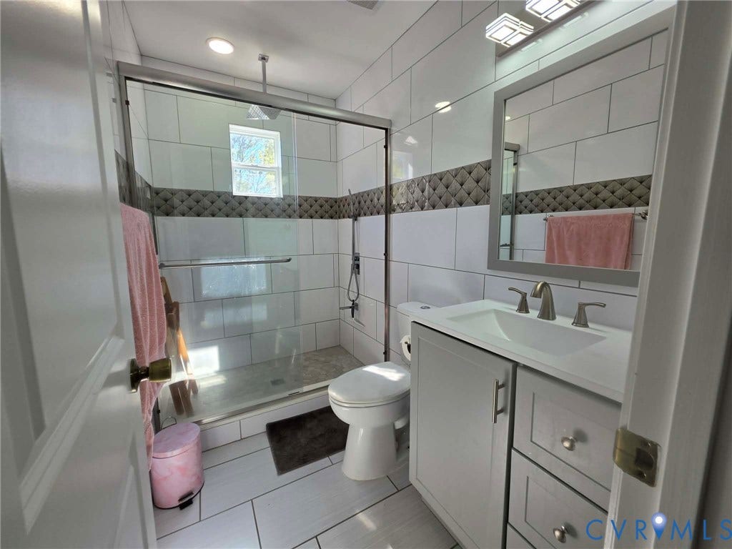 1351 Minefee Street, Bellemeade, Richmond, VA 23224 Full hallway bathroom featuring lovely ceramic tile work, a walk-in shower, modern lighting, and a gray vanity with sink.